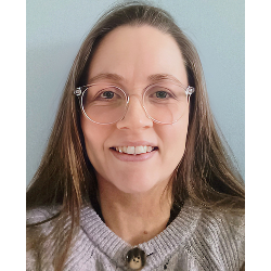 Louise Gray Headshot of Louise, in a grey cardigan and clear-framed glasses, smiling and facing the camera.